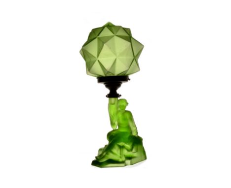 An Art Deco green glass table lamp, modelled as a lady sitting on the rocks, holding a star polygon shade, 39.5 cm high