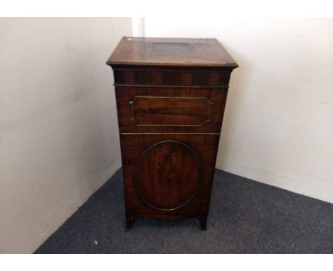 A Regency mahogany crossbanded inlaid and brass strung cellarette, leather insert to top, panel door with oval and rectangula