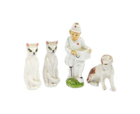 A group of early 20th Century ceramic figures, comprising a one legged organ grinder, 8.5 cm high; a pair of Siamese cats, 7 