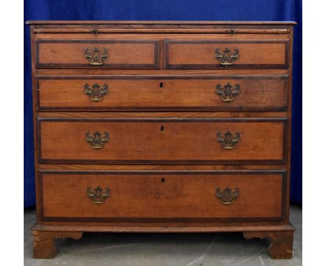 An oak and mahogany crossbanded chest-of-drawers, brushing slide over two short and three graduated long drawers, bracket fee