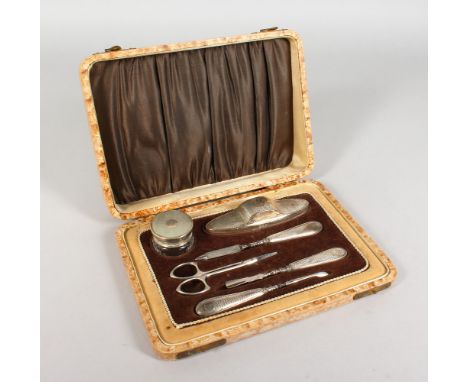 A SILVER MANICURE SET, with engine turned decoration, cased. Birmingham 1928-1930.