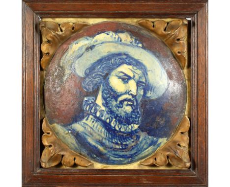 AN ITALIAN MAJOLICA TILE, depicting a man with a beard, wearing a hat, in an oak frame. 14ins wide.