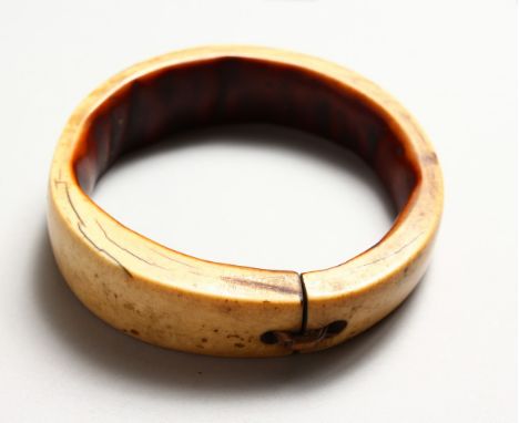 A GOOD IVORY TRIBAL BANGLE, 19TH CENTURY OR EARLIER, with old patination. 3.75ins diameter.