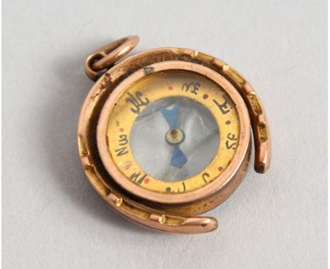 A SMALL GOLD COMPASS PENDANT.
