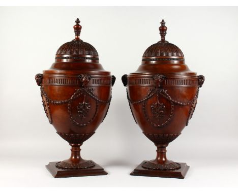 A VERY GOOD PAIR OF CHIPPENDALE DESIGN MAHOGANY CUTLERY URNS, with well carved rising tops, rams mask handles, harebell and r
