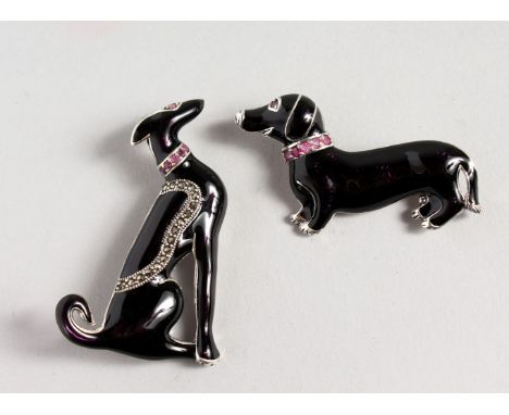 TWO SILVER AND ENAMEL DOG BROOCHES, with ruby collars.