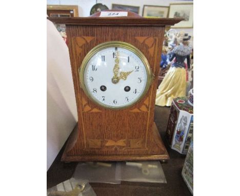 An Art Nouveau style oak inlaid mantle clock, with circular enamel dial
