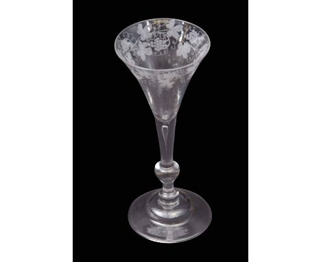 Mid-18th century light baluster wine glass with trumpet bowl engraved with fruiting vine above a tapered teared stem above in