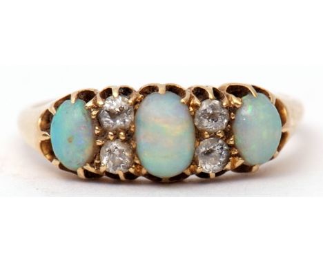 Late Victorian opal and diamond ring featuring three graduated oval cabochon opals highlighted with four small old cut diamon