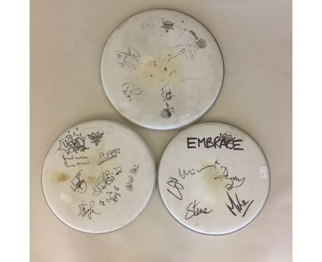 MADNESS/EMBRACE & SUPERGRASS DRUM SKINS. Three Remo drum skins, 1 with signatures from Suggs, Dan Woodgate, Mike Barson, Chas