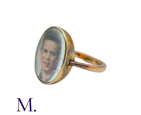 A Portrait Ring in 9k yellow gold, set with a portrait of a young man behind a glass face. Marked indistinctly 9.Size: O1/2We