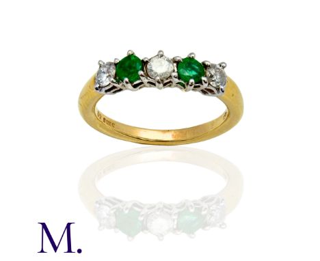 An Emerald and Diamond 5-Stone Ring in 18K yellow and white gold, set with three round cut diamonds (weighing approximately 0