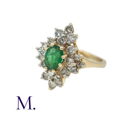 An Emerald And Diamond Cluster Ring in 14k yellow gold, set with a central oval shaped emerald of approximately 0.50cts surro