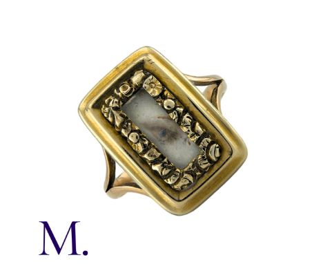 An Antique Lover's Eye Ring in 15k yellow gold, set with and ornate, foliate framed aperture featuring a miniature painted ey