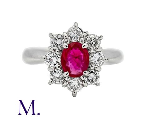 A Ruby & Diamond Cluster Ring in platinum, set with an oval cut ruby of approximately 0.65ct and diamonds in surround weighin