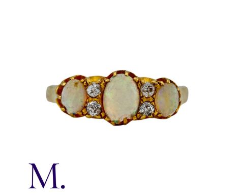 An Opal and Diamond Ring in 18K yellow gold, set with three oval cabochon opals with four round cut diamond accents.  Unmarke