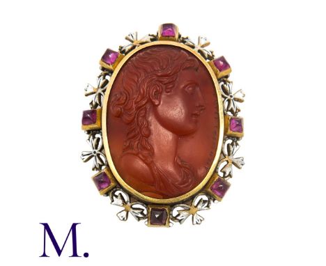 An Antique Carnelian, Ruby And Enamel Cameo Brooch in yellow gold, the carved carnelian cameo depicting a classical head in p