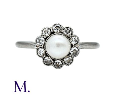 A Pearl And Diamond Cluster Ring in 18k white gold and platinum, set with a principal pearl of approximately 4.5mmwithin a ro