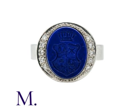 A Lapis Lazuli and Diamond Signet Ring set in 18K white gold, with carved intaglio in lapis lazuli with diamonds in surround.