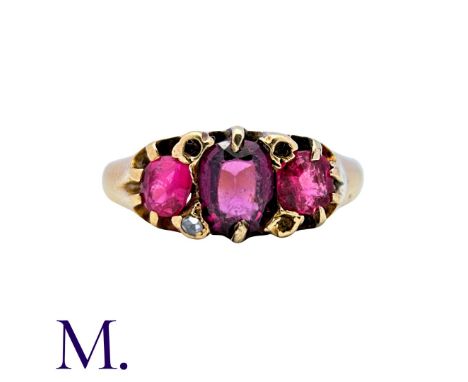 An Antique 3-Stone Garnet/Ruby Ring in 18ct yellow gold, set with an oval-cut garnet to the centre and two round cut garnets 