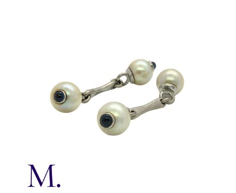 A Pair of Pearl and Sapphire Cufflinks in white gold set with pearls of approximately 7.5mm diameter with inset cabochon sapp
