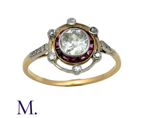 An Antique Ruby and Diamond Target Ring in 18K yellow gold, set with an old cut diamond to the centre, calibrated rubies in s
