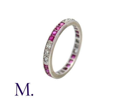 An Antique Ruby and Diamond Eternity Ring in white gold, set all around with alternating sections of round cut diamonds and s