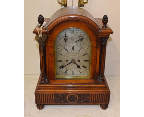 An oak striking table clock, circa 1890, arched case with acorn finials, side sound frets, silvered dial elaborately engraved