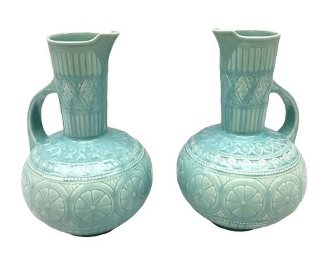 Pair of Lear pottery jugs with a blue ground and floral decoration, both with impressed print beneath, H25cm 