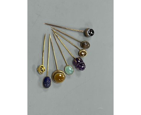 A small collection of eight assorted mainly yellow metal and chalcedony set stick pins, including Scarab, amethyst frog and b