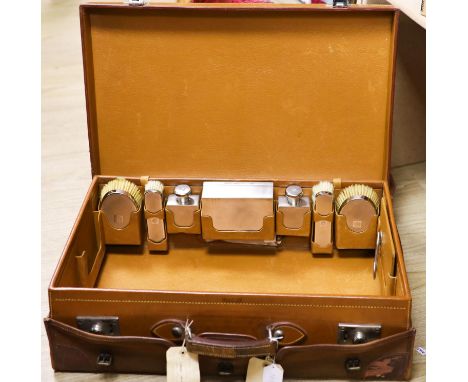 A 1930's Harrods pigskin travelling toilet case with seven engine turned silver fittings, including brushes, cigarette box an