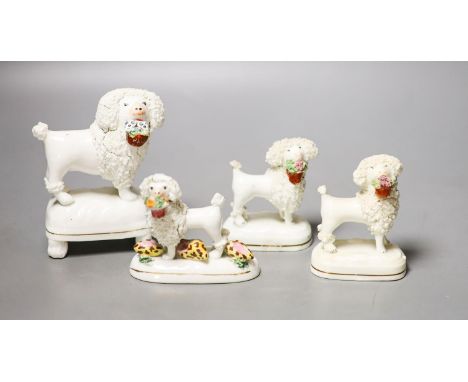 Four Staffordshire porcelain figures of poodles holding a basket of flowers, c.1830-50, one modelled with shells to the baseP