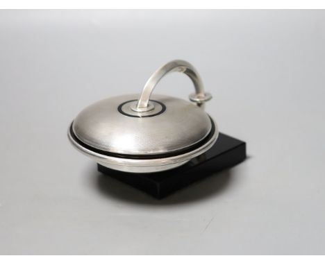 An unusual Art Deco engine turned silver and black enamel circular compact, with support arm, on black onyx? base (a.f.), Coh