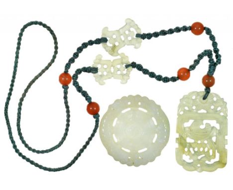 A CHINESE CARVED AND PIERCED JADE PENDANT, 60 X 40MM, IN THE DESIGN OF A PHOENIX, ON A SILK CORD NECKLACE LINKED BY TWO JADE 