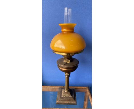 Large brass oil lamp with amber coloured shade 