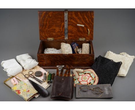 An oak box containing a collection of textiles, sewing requisites, etc, including two needle dispensers by Abel Morrall Ltd a
