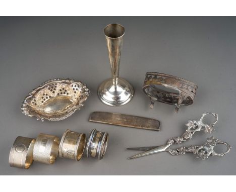 A small parcel of silver, comprising four various napkin rings, a late Victorian bonbon dish with repousse and pierced decora