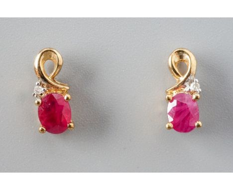 A pair of 9ct yellow gold ruby and diamond stud earrings, set with oval mixed-cut rubies and a small round brilliant-cut diam