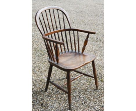 An antique elm seat hoop and stick-back Windsor chair, raised on turned legs and stretchers 