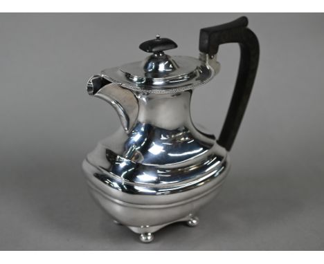 An Edwardian silver hot water jug in the Regency Revival manner, with gadrooned rim, composite handle and finial, on bun feet
