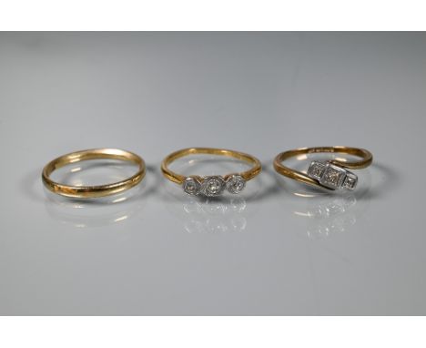 A 9ct yellow gold narrow wedding band, size R, to/w a three stone diamond ring set 18ct and plat (misshapen) and another thre