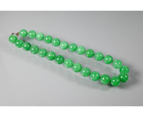 A uniform row of green jade beads, double knotted throughout, each bead approx 1.4 cm diam, 41 cm long (open) 