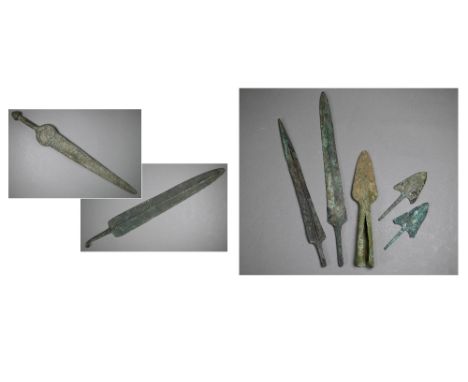 A Bronze Age sword, the tapering fullered blade with midrib, extending from oval shoulder, with column grip and domed pommel,