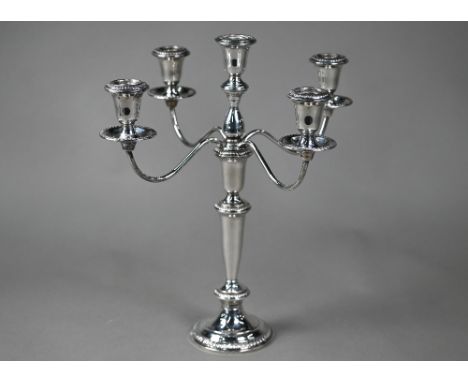 A US weighted Sterling four branch candelabrum with five sconces, the top unscrewing to leave a simple pillar candlestick, 37