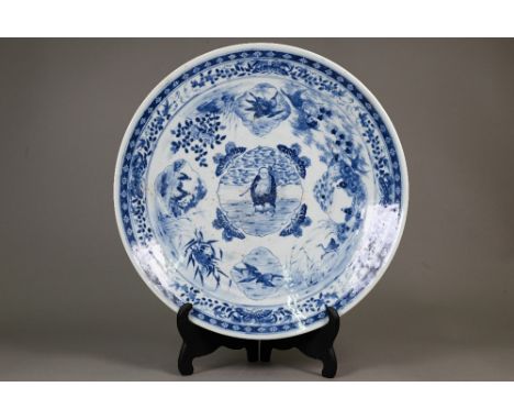 A 19th century Chinese blue and white charger painted in underglaze blue, the central shaped cartouche featuring an immortal,
