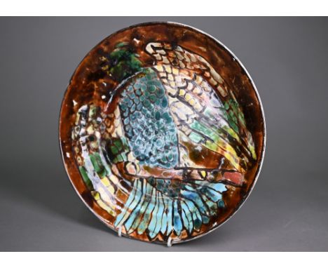 A Poole Studio pottery charger, painted with a parrot by Betty Banton, 31 cm diameter