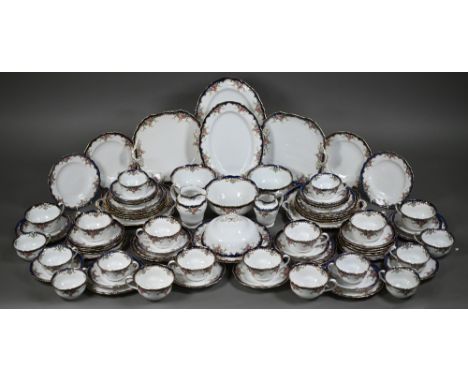 An Edwardian Copeland Spode part dinner/tea service printed with rose vignettes on a blue and gilt rim, 79 pieces 