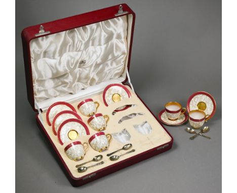 A Royal Worcester set of six coffee cups and saucers with delicate seaweed decoration within gilt and puce rims, dated 1934, 