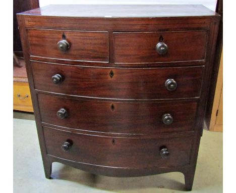 A regency mahogany bowfronted chest of three long and two short drawers on splayed supports, the caddy top with ebony inlaid 