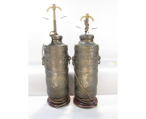 A pair of bronze table lamps in the form Tibetan Prayer Wheels, with loop handles and two adjustable lights. 56cm - 83cm. 